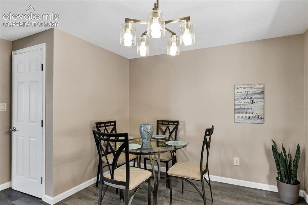 Image 7 of 46: Spacious room with wood-finish flooring, neutral-toned walls, and a contemp