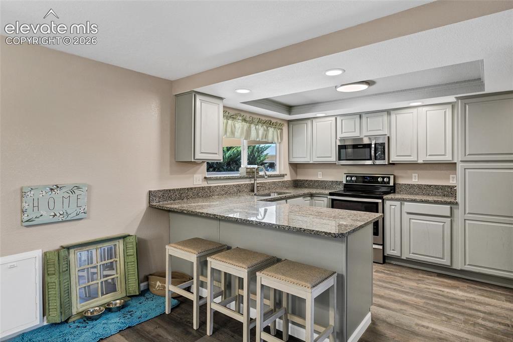 Image 8 of 46: Wood-finish flooring with fresh paint and new white baseboards