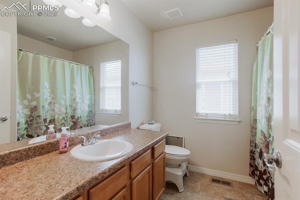 Image 36 of 49: Full bath with vanity, visible vents, baseboards, and toilet