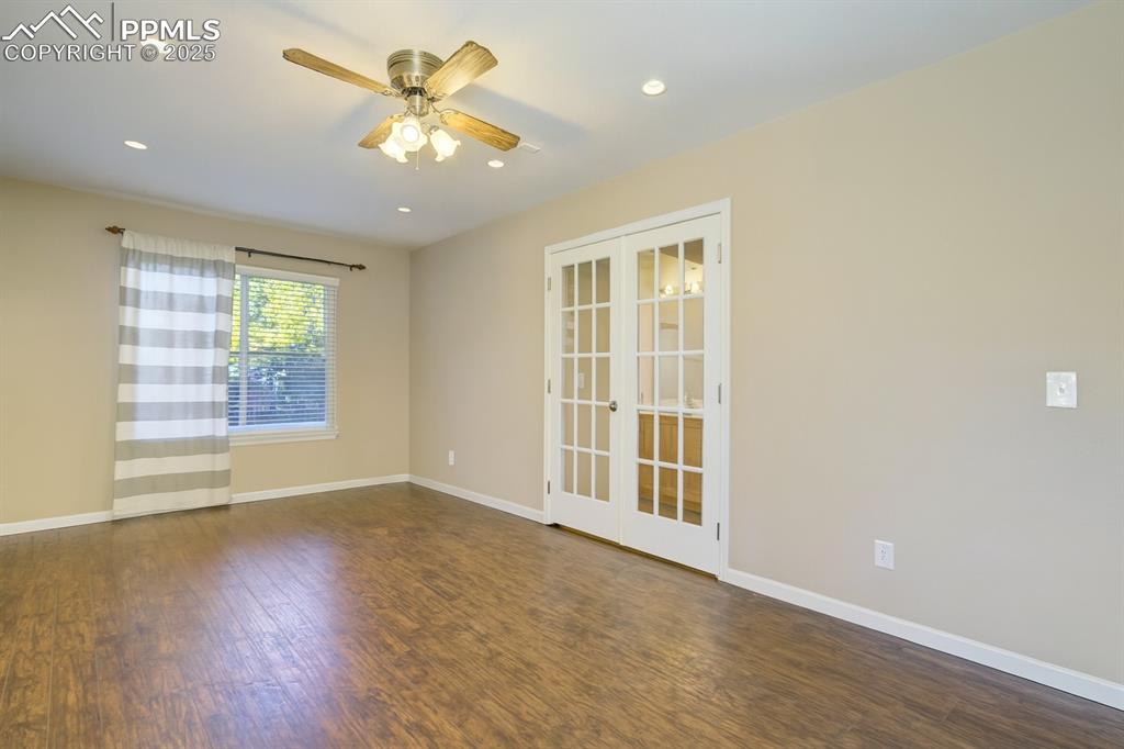 Image 25 of 50: Spare room with french doors, dark wood-style flooring, recessed lighting, 