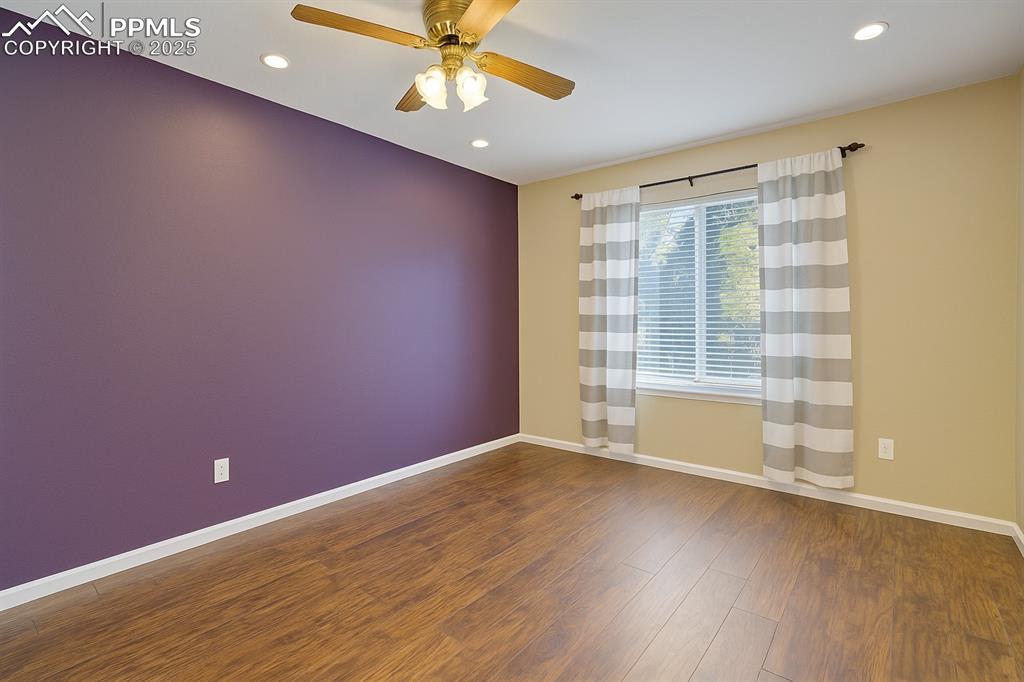 Image 26 of 50: Unfurnished room with dark wood finished floors, recessed lighting, and a c