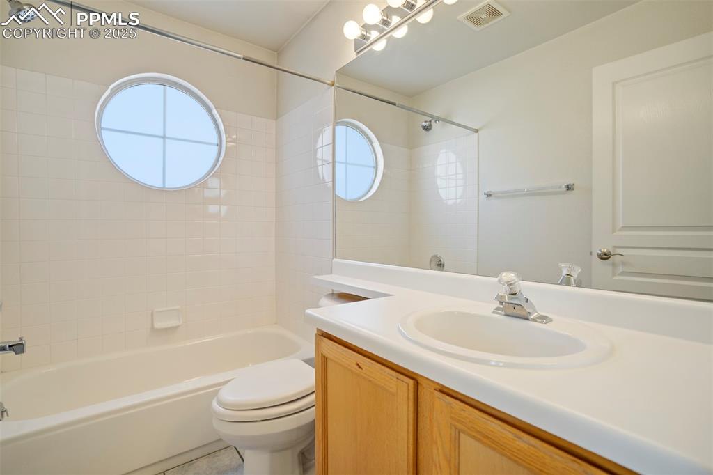 Image 31 of 50: Full bathroom with vanity, plenty of natural light, and  shower combination