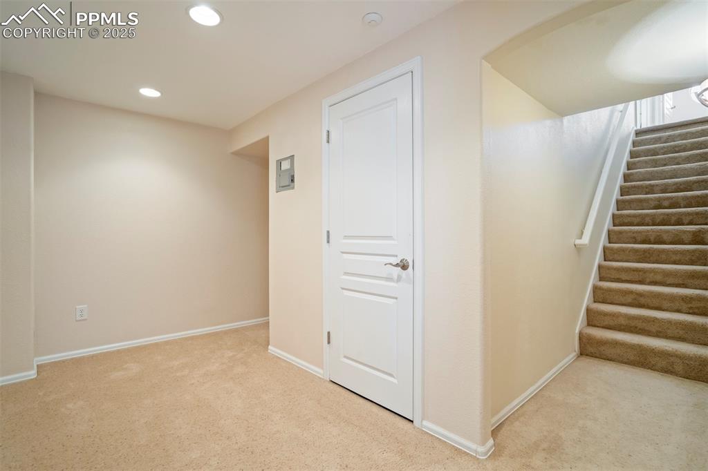 Image 34 of 50: Below grade area featuring light carpet, recessed lighting, and stairway