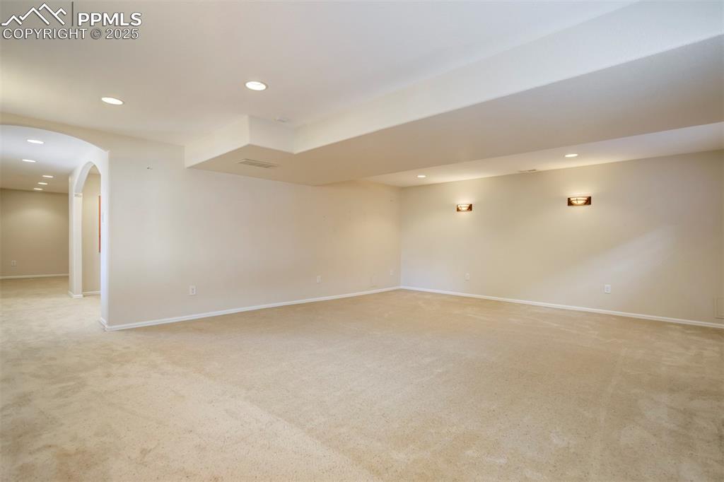 Image 37 of 50: Empty room featuring recessed lighting, light colored carpet, and arched wa