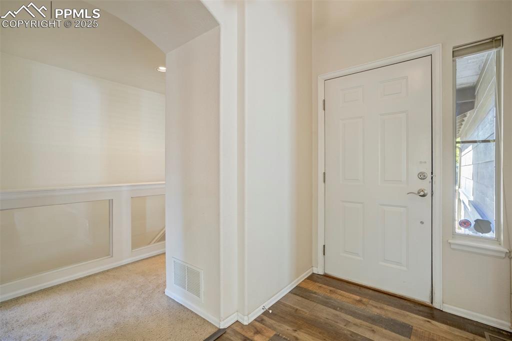 Image 7 of 50: Foyer featuring arched walkways and wood finished floors