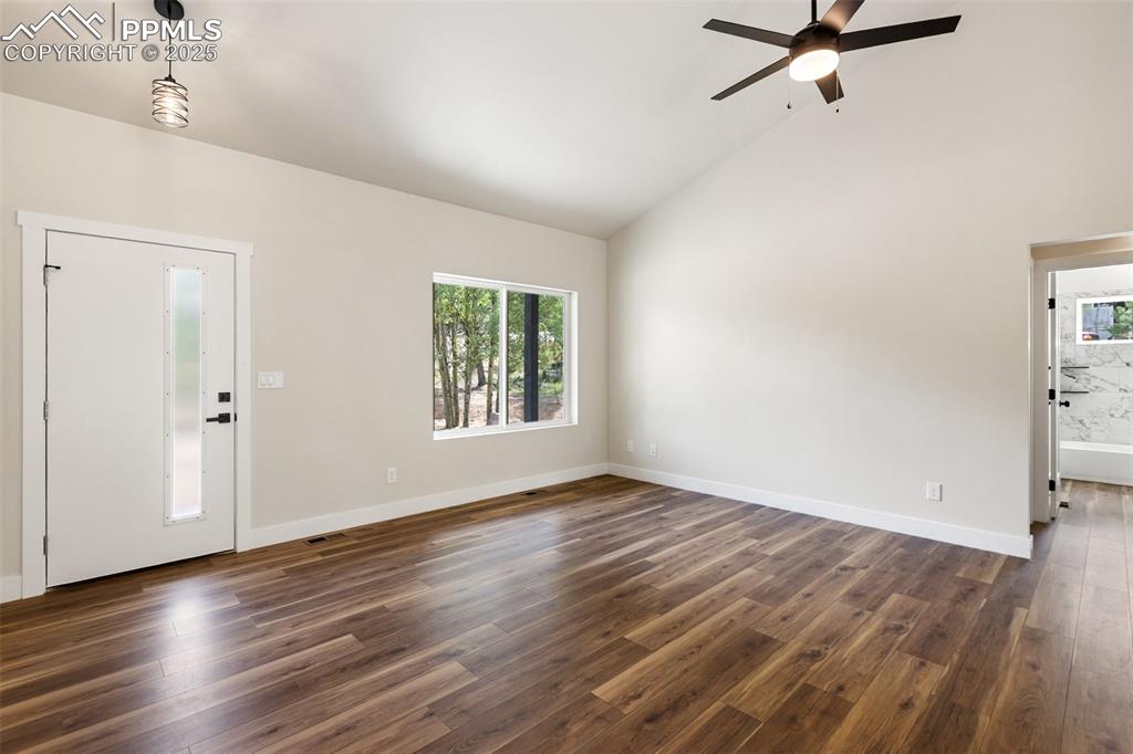 Image 12 of 35: Foyer entrance featuring dark wood finished floors, high vaulted ceiling, a