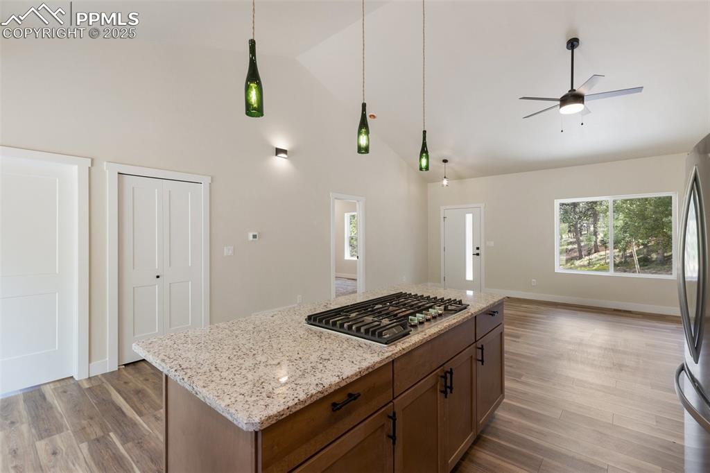 Image 15 of 35: Kitchen with dark wood-style flooring, a center island, ceiling fan, light