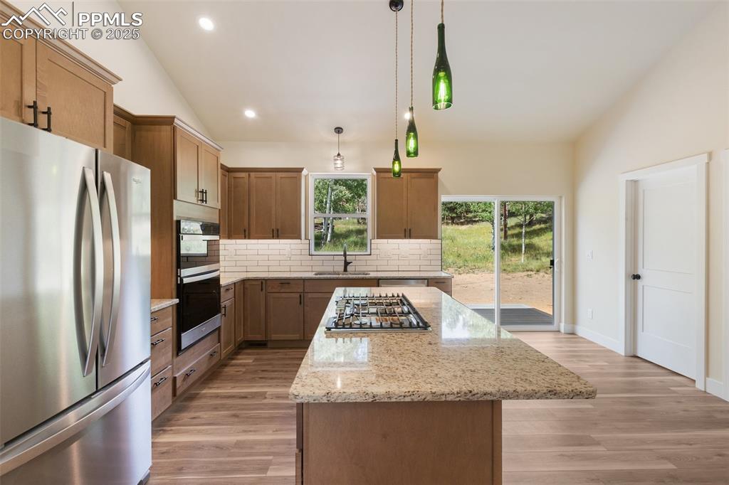 Image 17 of 35: Kitchen featuring stainless steel appliances, a kitchen island, tasteful ba