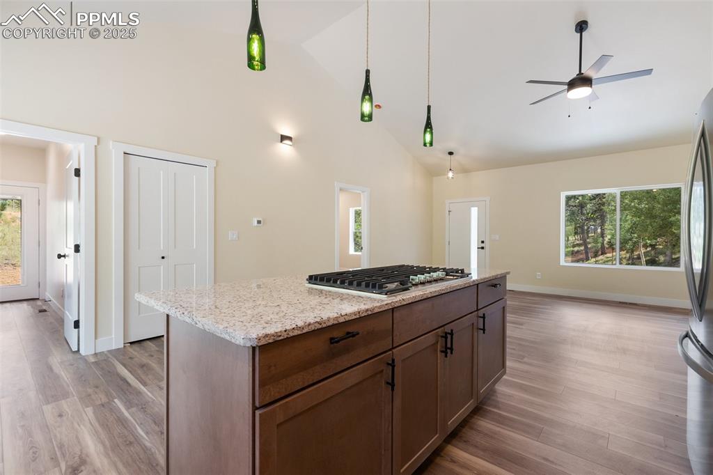 Image 18 of 35: Kitchen with healthy amount of natural light, a kitchen island, light wood-