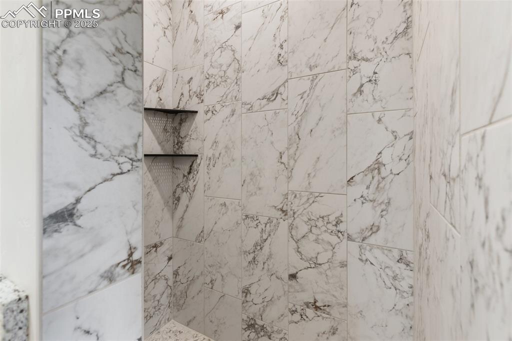 Image 23 of 35: Bathroom view of a marble finish shower