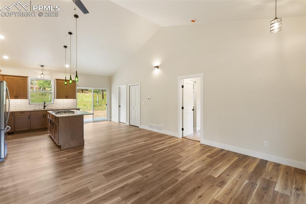 Image 9 of 35: Kitchen featuring pendant lighting, a kitchen island, high vaulted ceiling,