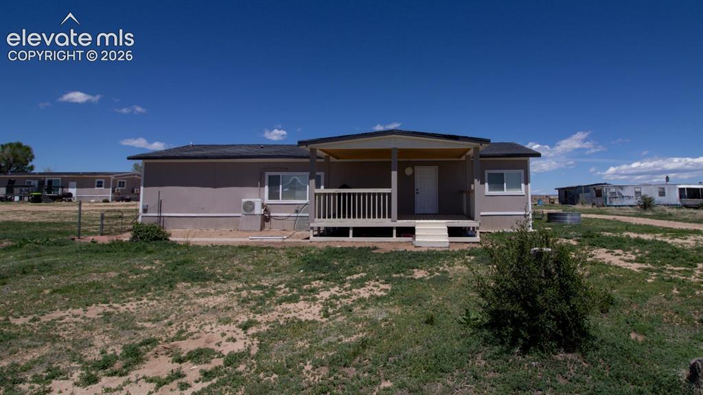 Image 16 of 25: Back of house with a lawn and a cooling unit