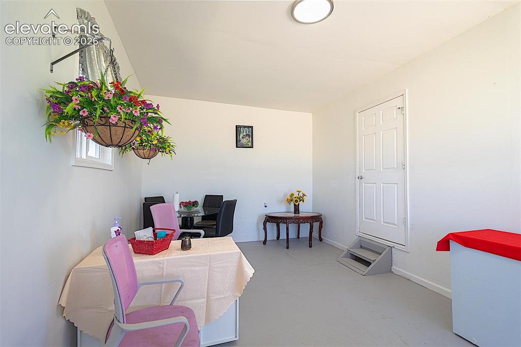 Image 18 of 25: Home office with concrete flooring and baseboards