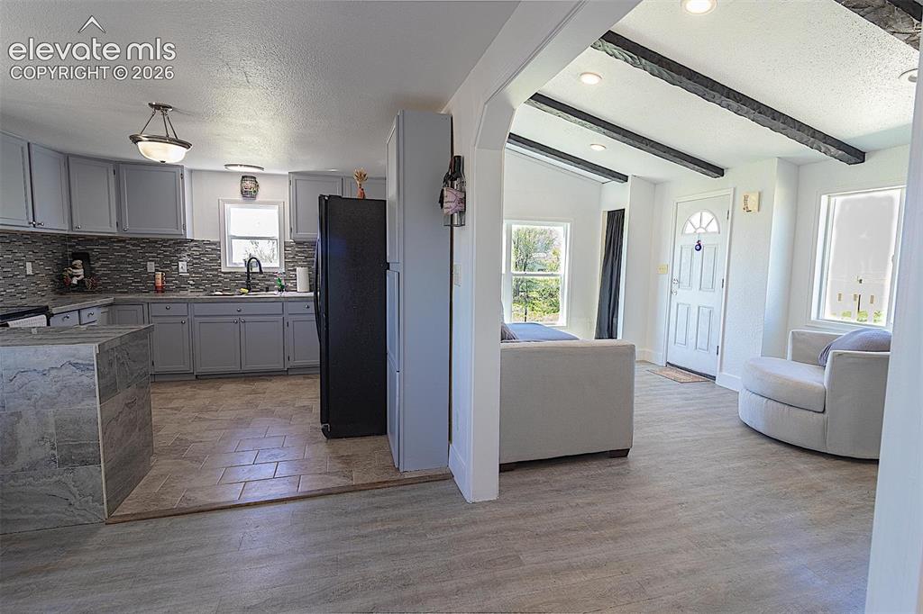 Image 6 of 25: Kitchen with freestanding refrigerator, healthy amount of natural light, ba