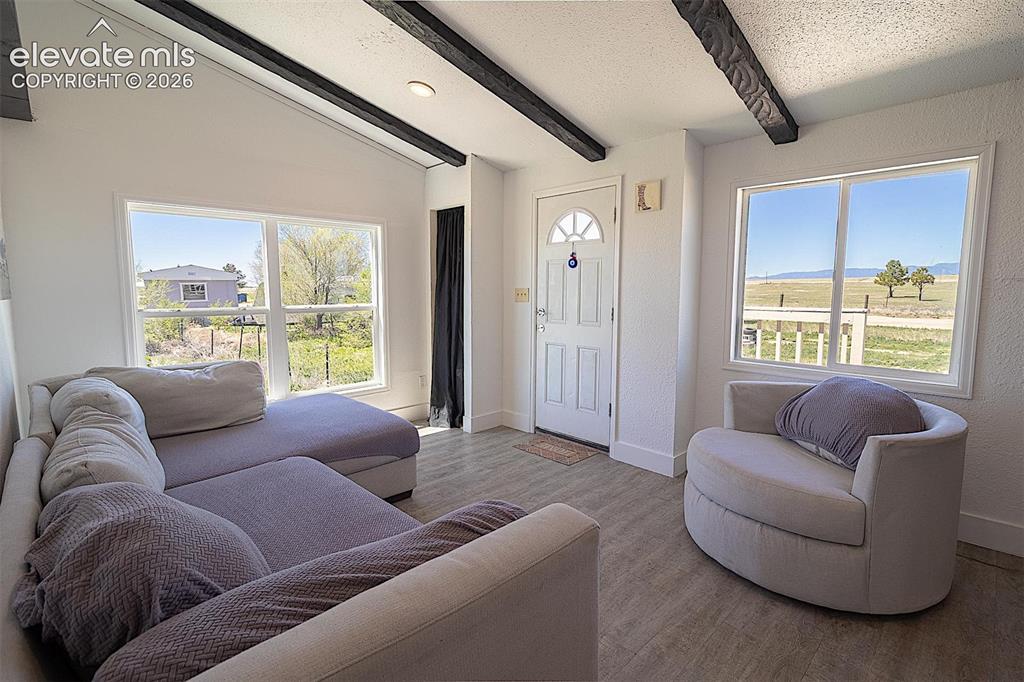 Image 7 of 25: Living area featuring baseboards and wood finished floors