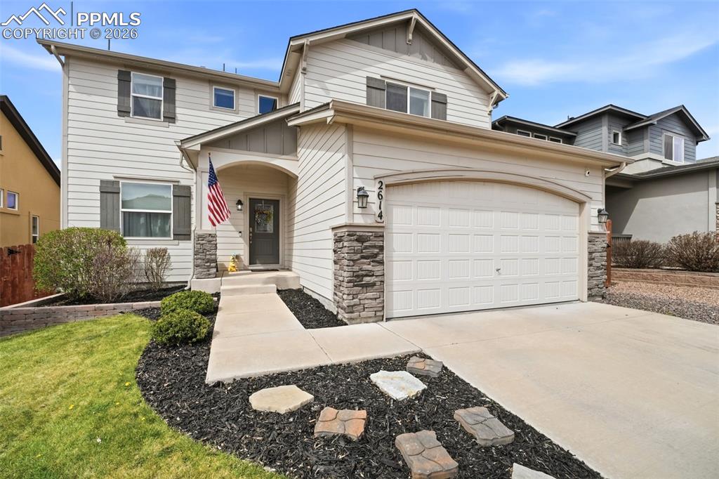 Image 1 of 48: View of front facade featuring driveway, stone siding, board and batten sid