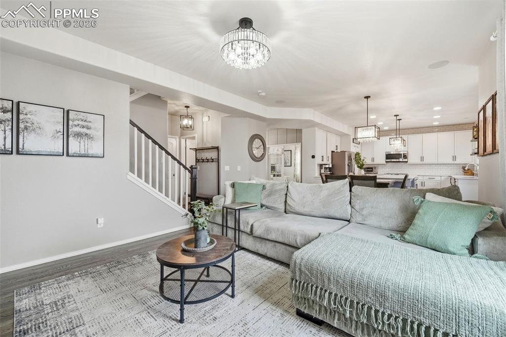 Image 11 of 48: Living area with hanging lights and light wood finished floors