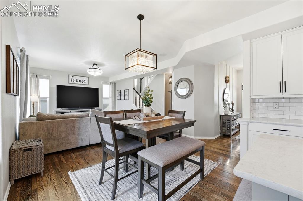 Image 13 of 48: Dining space featuring stairway and dark wood-style floors