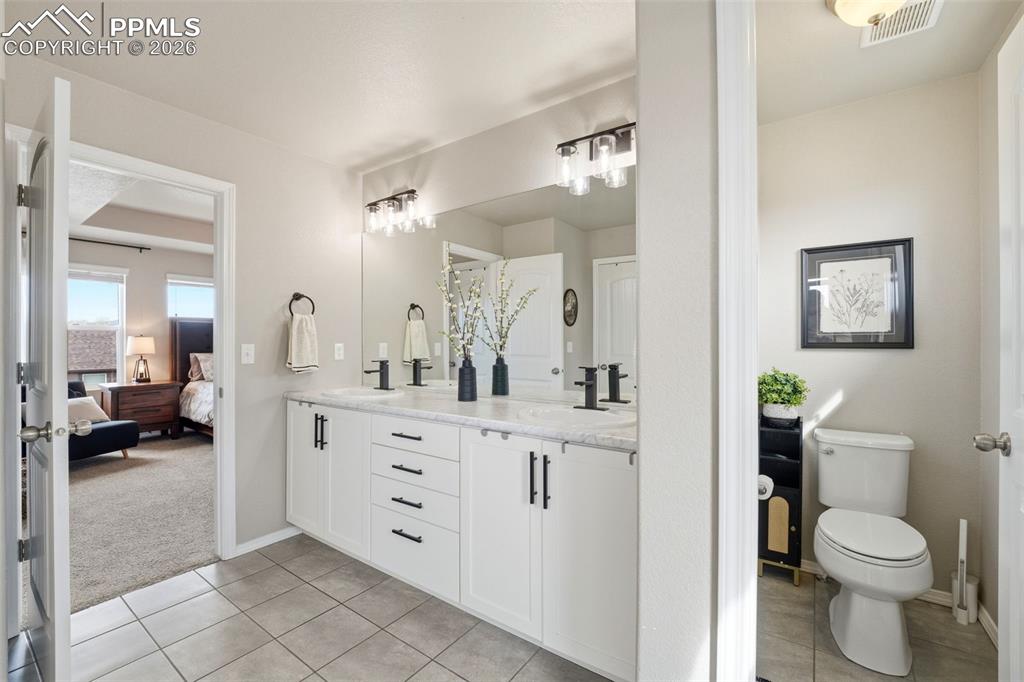 Image 22 of 48: Ensuite bathroom featuring double vanity, light colored carpet, and light t