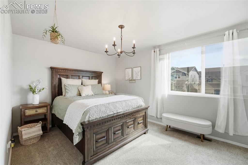 Image 26 of 48: Bedroom featuring carpet and a chandelier