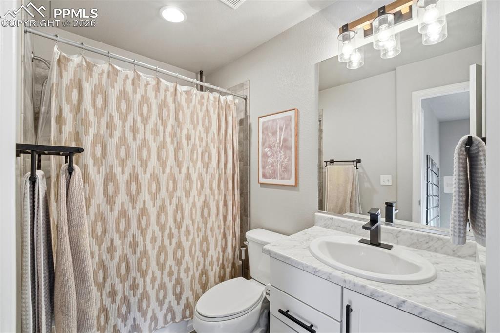 Image 27 of 48: Full bathroom with vanity and curtained shower