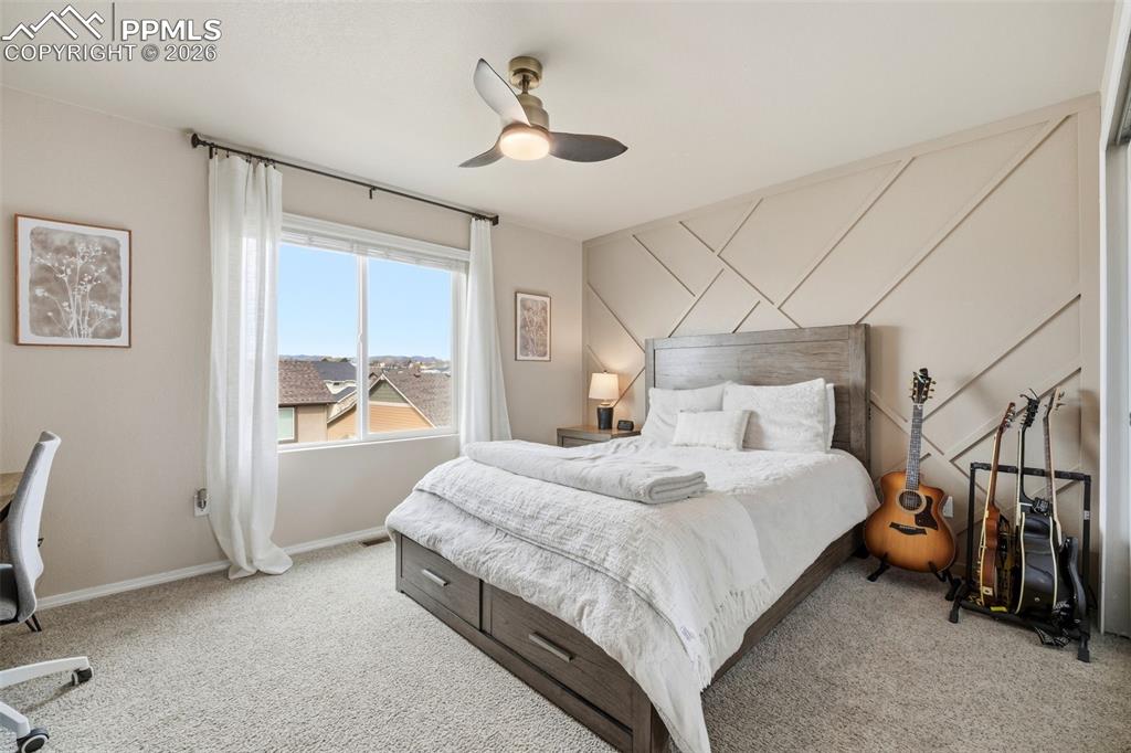 Image 28 of 48: Bedroom featuring light colored carpet, ceiling fan, and a desk