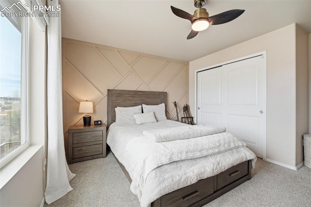 Image 29 of 48: Bedroom with a ceiling fan, a closet, and light carpet