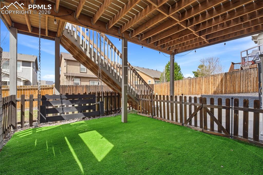 Image 41 of 48: Fenced backyard with stairway and a deck