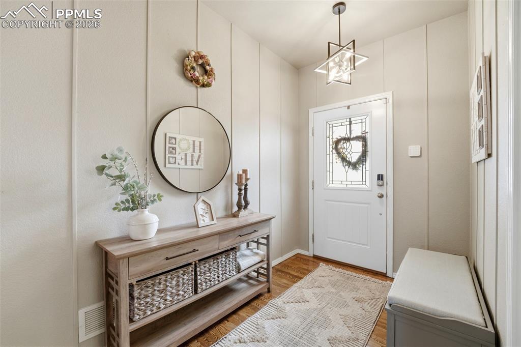 Image 6 of 48: Entryway featuring light wood-style floors and hanging lights