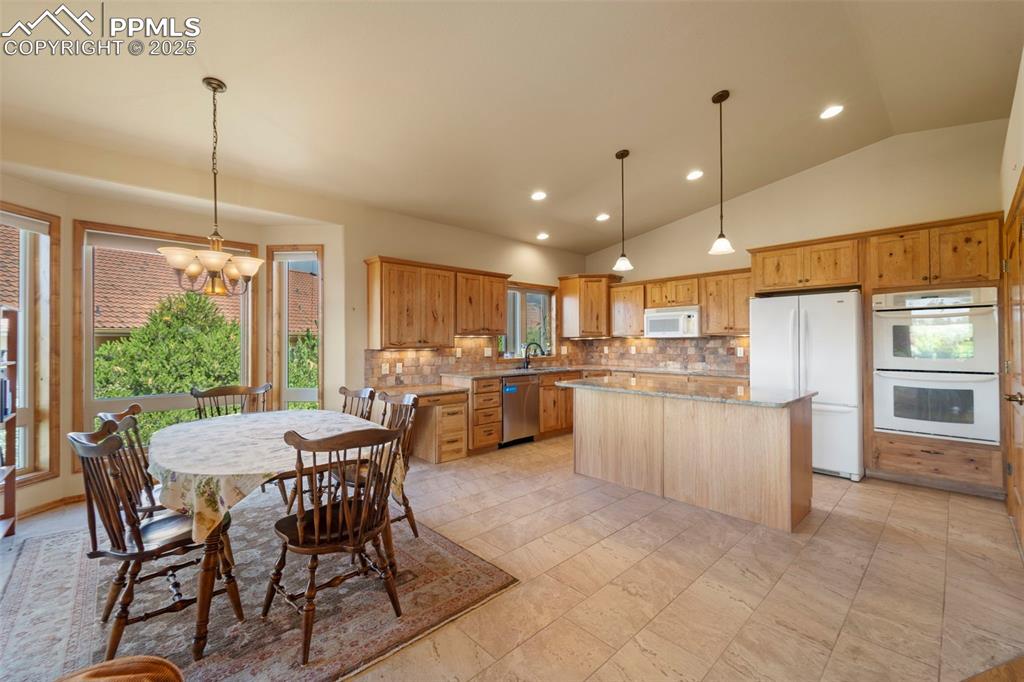 Image 7 of 33: Gorgeous kitchen with dining area, kitchen island, double ovens, and huge p