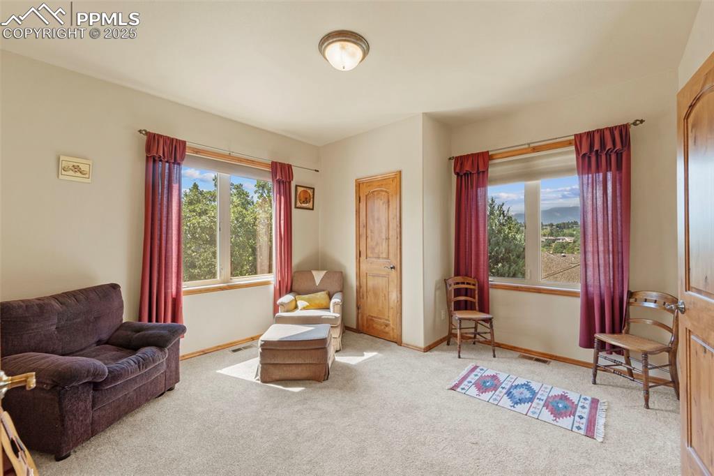 Image 9 of 33: Carpeted upper bedroom off the front entry includes attached full bathroom