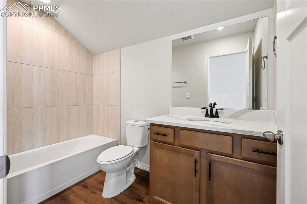 Image 10 of 36: Full bath with vanity, dark wood-type flooring, bathtub / shower combinatio
