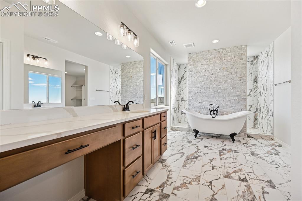 Image 15 of 36: Bathroom with vanity, a freestanding tub, recessed lighting, light marble f