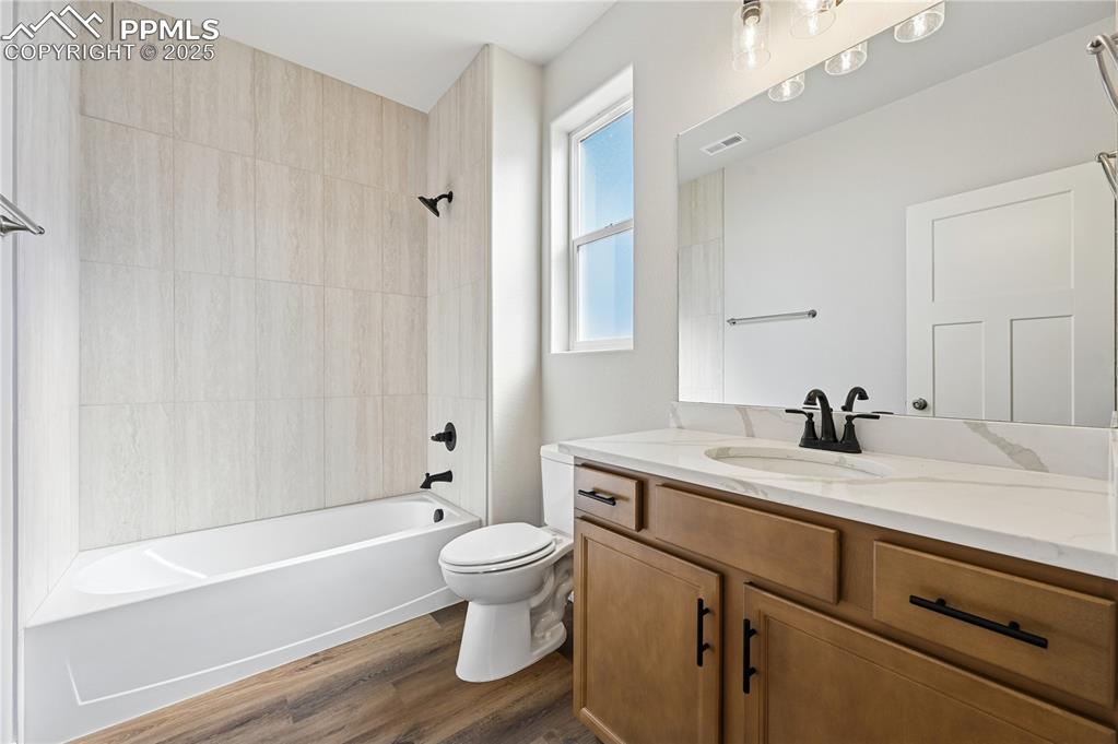 Image 19 of 36: Full bath with washtub / shower combination, vanity, and dark wood finished