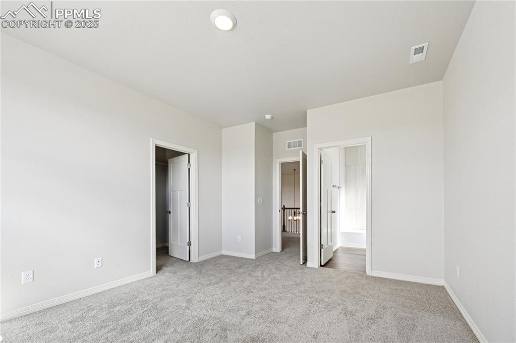 Image 20 of 36: Unfurnished bedroom with light carpet and ensuite bathroom