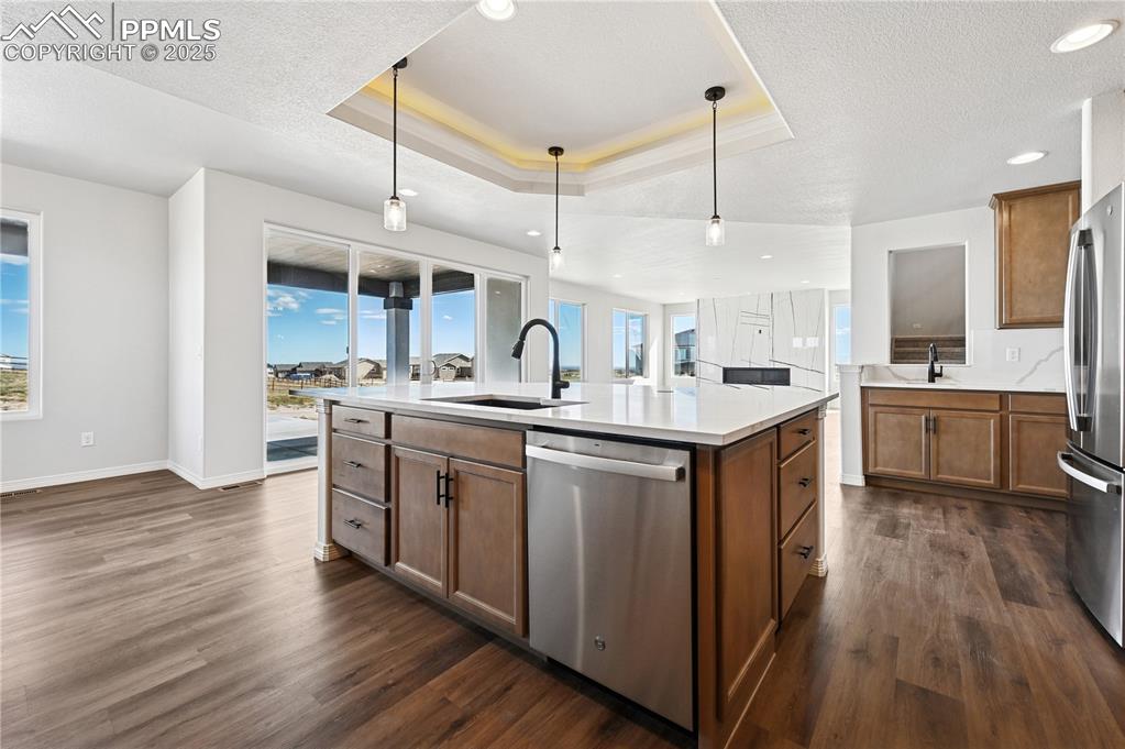 Image 23 of 36: Kitchen featuring brown cabinets, appliances with stainless steel finishes,