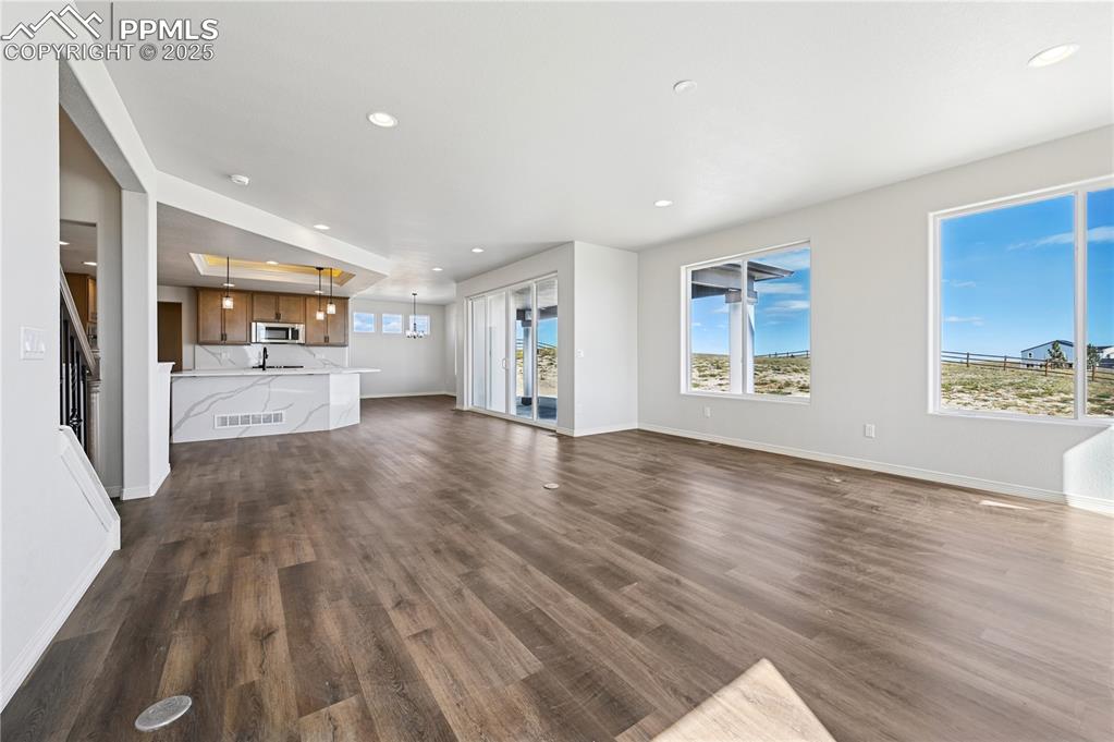 Image 28 of 36: Unfurnished living room with recessed lighting, dark wood-style flooring, a