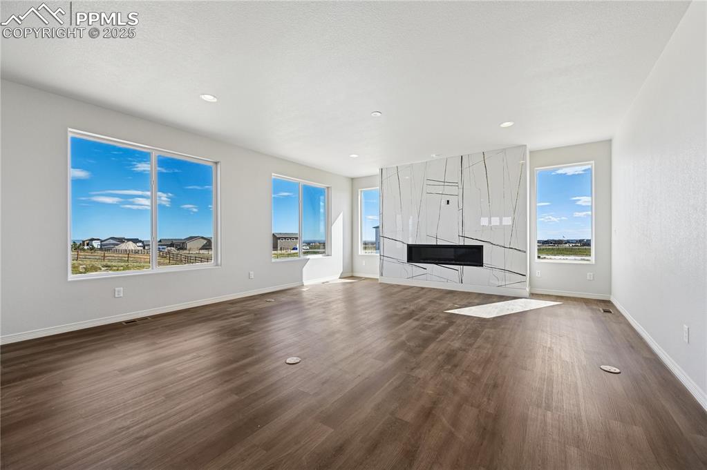 Image 29 of 36: Unfurnished living room with dark wood-style flooring and recessed lighting