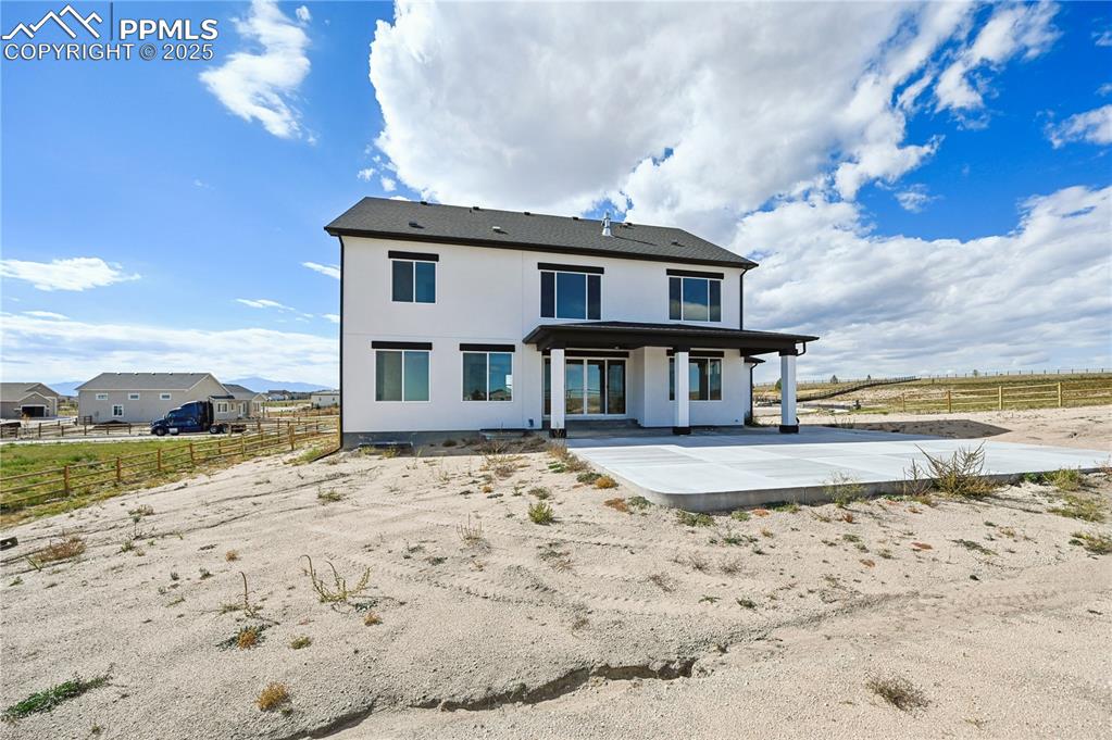 Image 3 of 36: Back of property with a patio area and stucco siding
