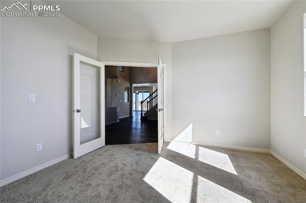 Image 33 of 36: Unfurnished room featuring carpet floors and stairway