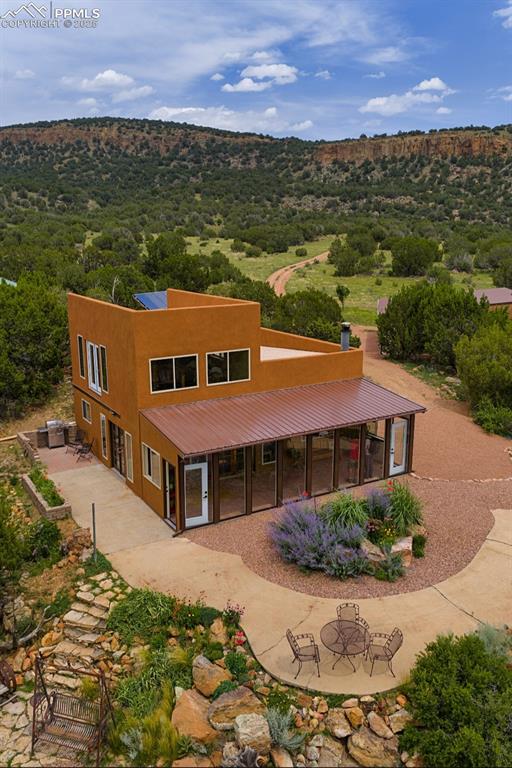 Caption: Back of property with stucco siding, a sunroom, and a wooded view