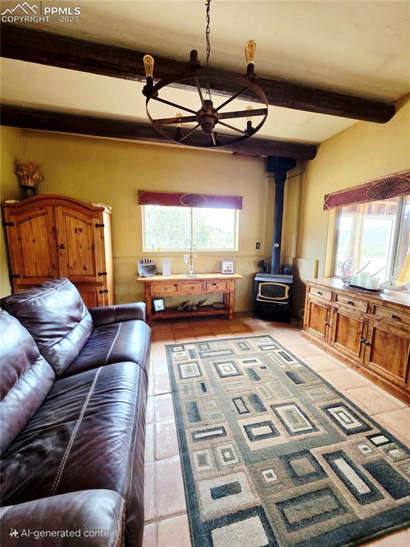 Image 10 of 42: Living room featuring beamed ceiling, a wood stove, and light tile patterne