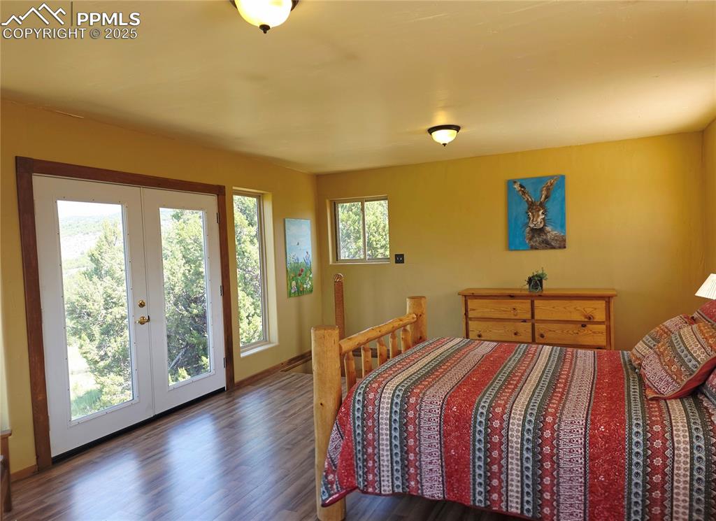 Image 16 of 42: Bedroom featuring access to outside, wood finished floors, and french doors