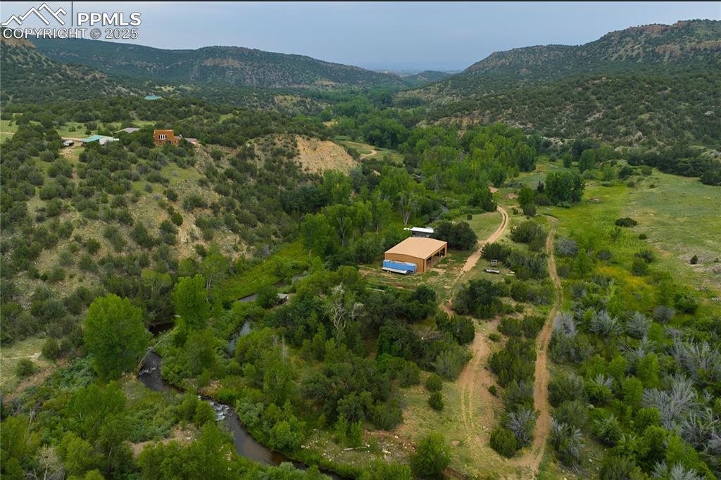 Image 36 of 42: Aerial view of sparsely populated area featuring a mountain backdrop
