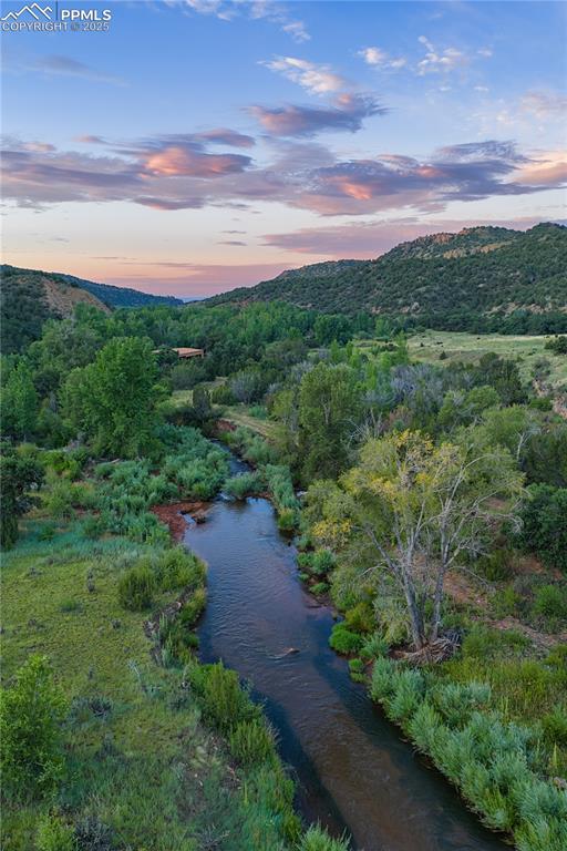 Image 39 of 42: Aerial view at dusk of a water and mountain view