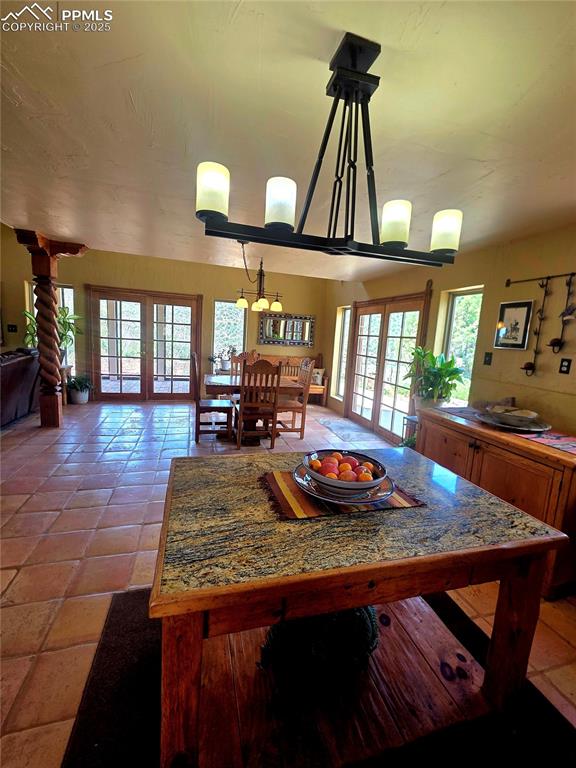Image 7 of 42: Dining space featuring french doors and light tile patterned flooring