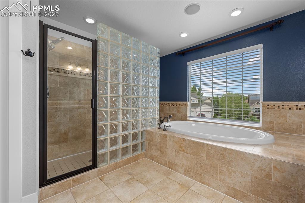 Image 13 of 24: Bathroom featuring a stall shower, a garden tub, tile patterned flooring, a