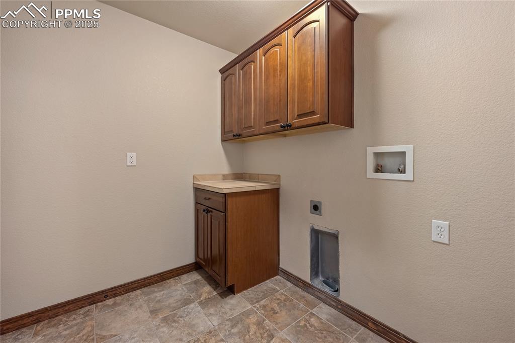Image 15 of 24: Laundry area featuring cabinet space, electric dryer hookup, hookup for a w