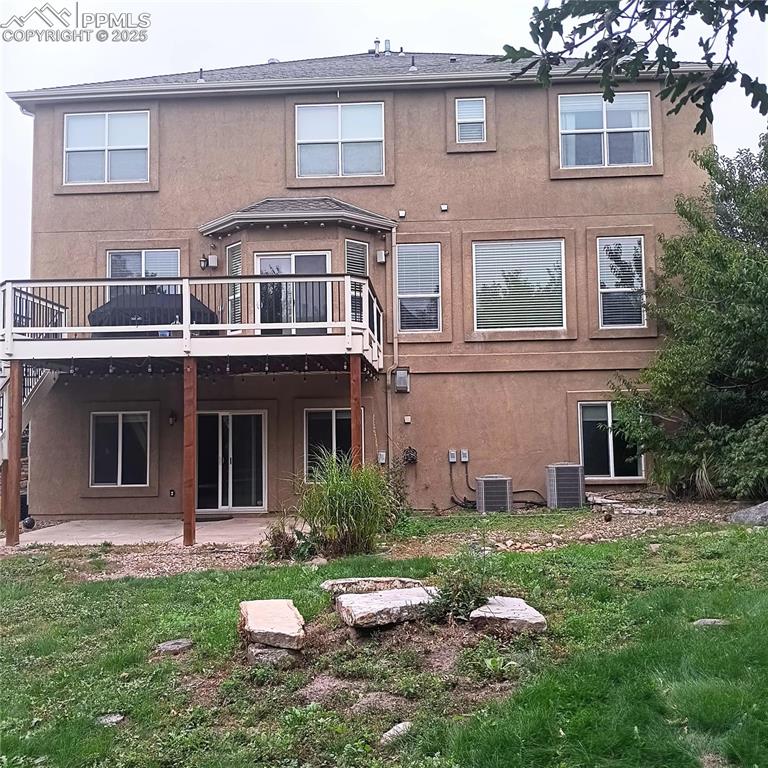 Image 24 of 24: Rear view of property featuring a patio area, a yard, stucco siding, and de