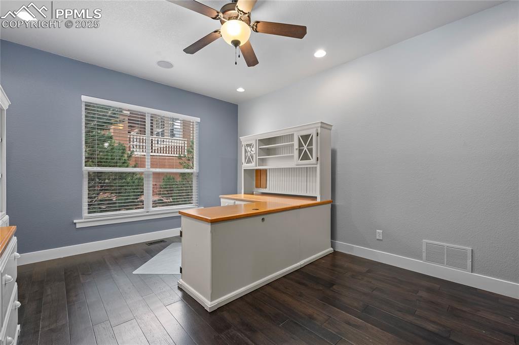 Image 9 of 24: Main Floor Office with dark wood-style flooring, recessed lighting and a ce